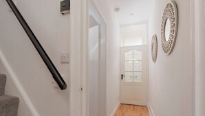 Ein Flur mit Treppe, einer Tür und Wanddekoration.