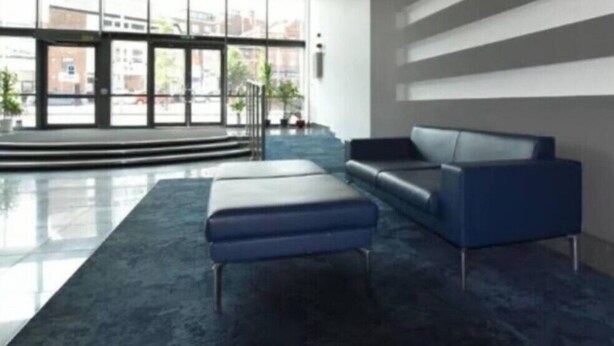 A modern lobby with a blue sofa, a large window, and a chandelier. - Cosy Apartment with great Wi-Fi, City Centre (Nottingham)