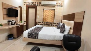 A bedroom with a bed, a desk, a chair, and an air conditioning unit. - HOTEL DREAM PALACE (Basai)