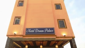 A building with a sign reading 'Hotel Dream Palace' at the entrance, featuring a red carpet and a staircase leading up. - HOTEL DREAM PALACE (Basai)