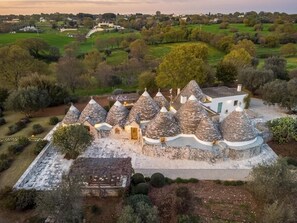 Einzigartige Architektur mit kegelförmigen Dächern, umgeben von einem angelegten Garten und weiter Blick auf eine Stadt.