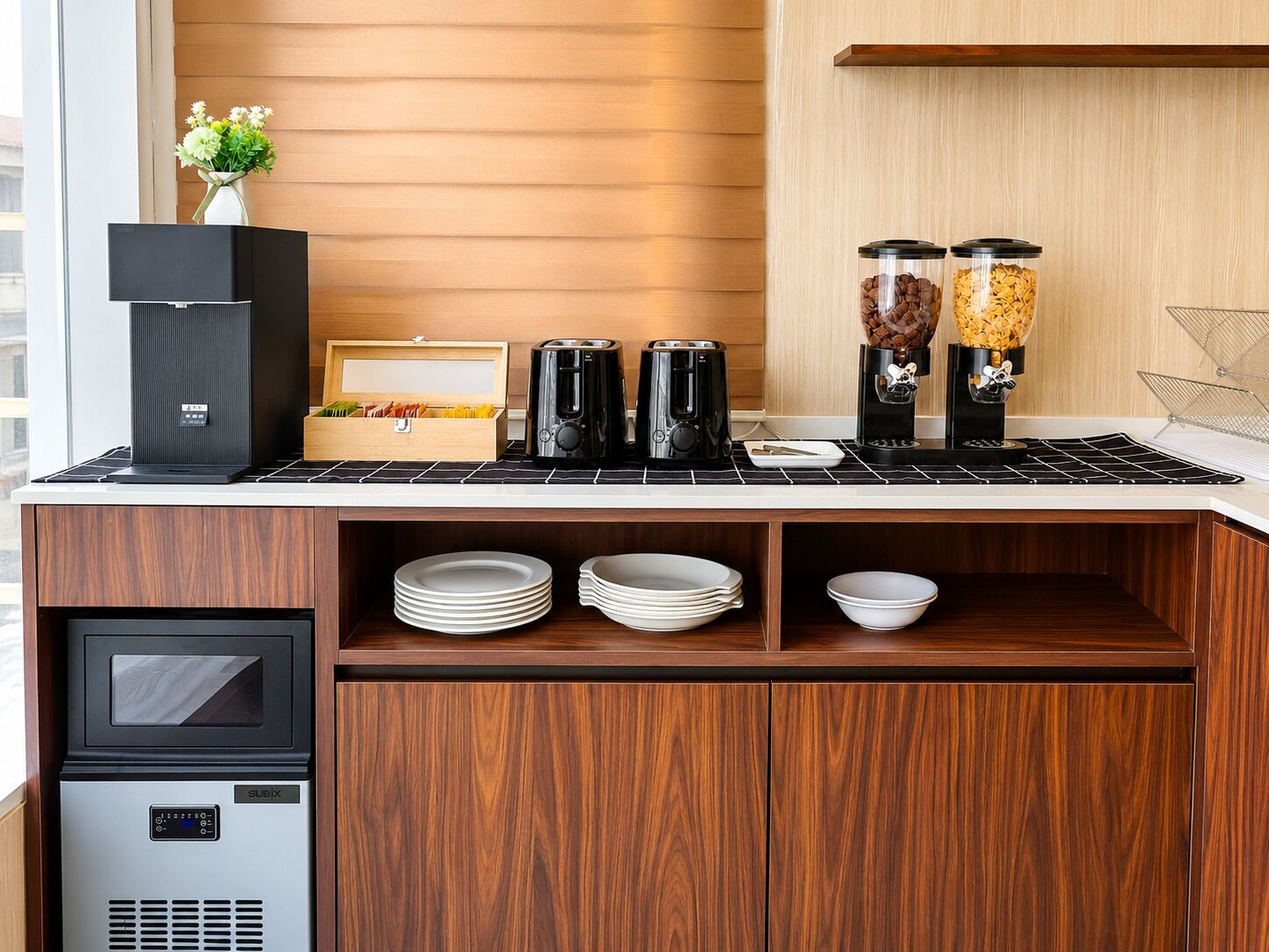 A kitchenette with a coffee maker, a rice cooker, and a small refrigerator.