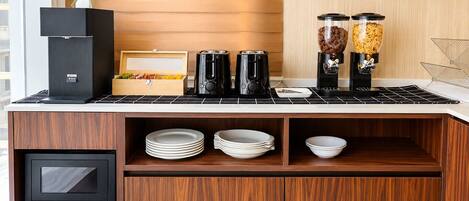 A kitchenette with a coffee maker, a rice cooker, and a small refrigerator.