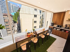 Una cocina moderna con barra, ventanas amplias y vistas a la ciudad.