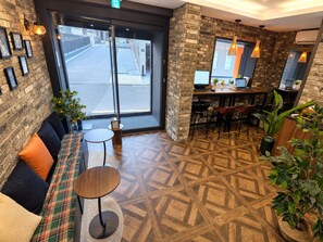 A modern interior with a seating area, a bar, and a view of the street.