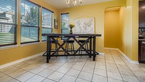 A kitchen with a dining table, large windows, and a map on the wall. - Alamo Heights Haven+15 min 2 Seaworld+Pet Friendly (San Antonio)