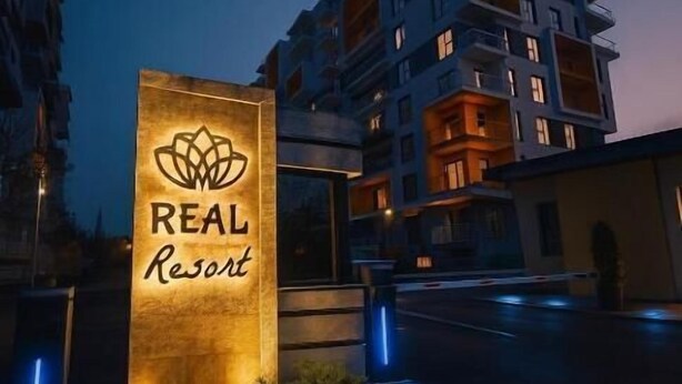 Un edificio de varios pisos con un letrero que dice 'REAL Resort'.