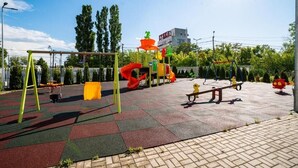 Un parque infantil con columpios, un tobogán y un sube y baja.