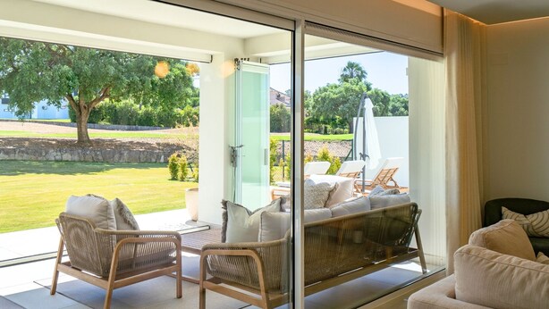 Una sala de estar moderna con un ventanal que da a un patio.