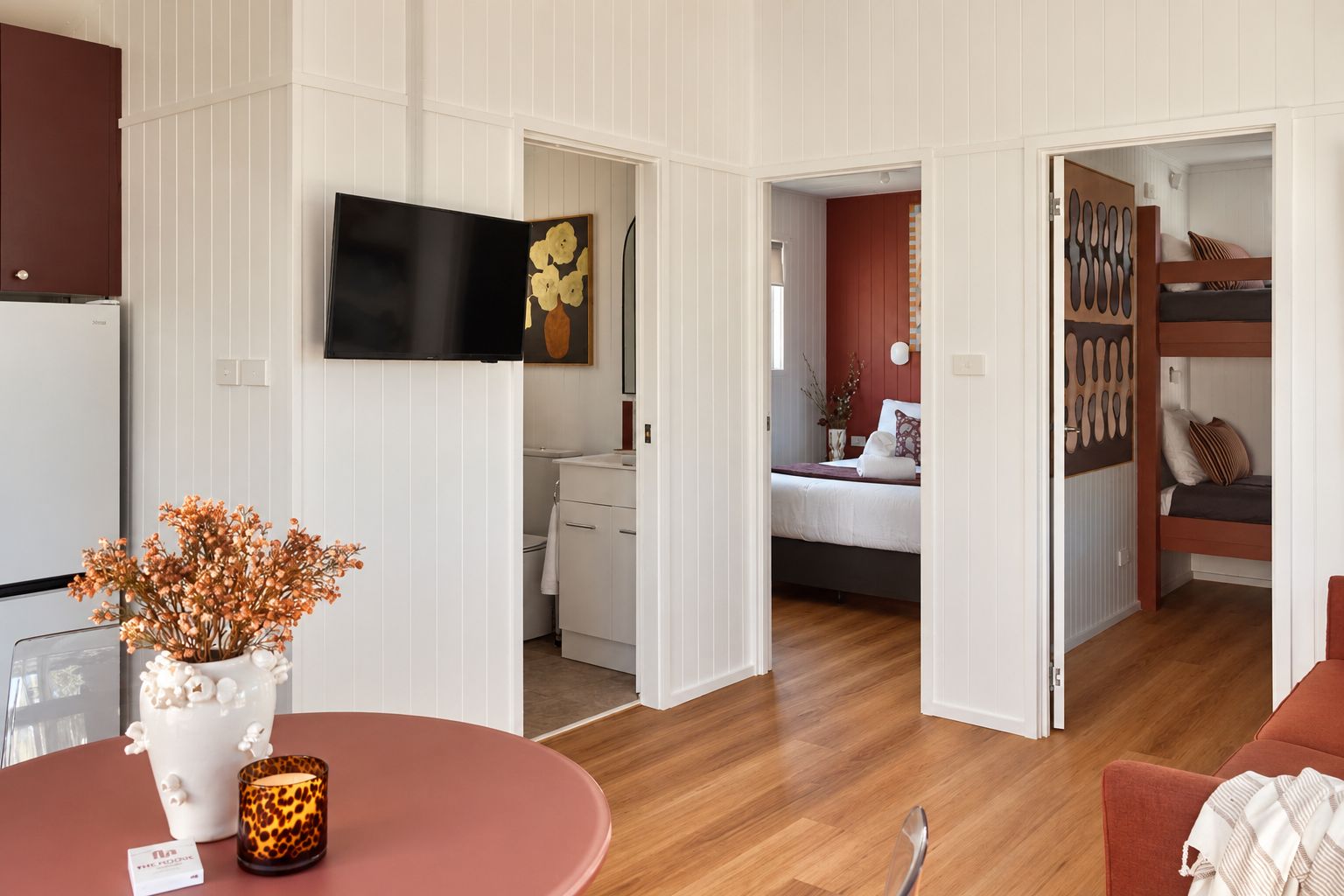 A modern interior with a dining area, a kitchen, a bedroom, and a bathroom.