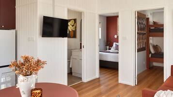 A modern interior with a dining area, a kitchen, a bedroom, and a bathroom.