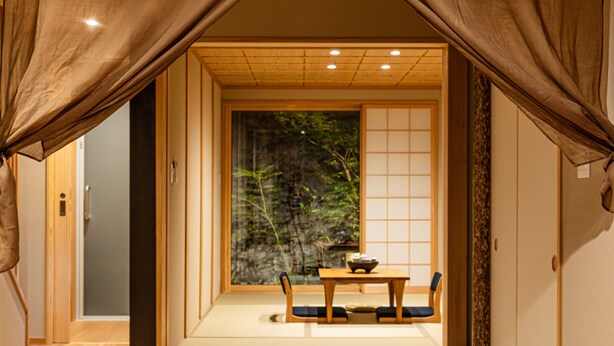 Et traditionelt japansk rum med tatamimåtter, et lavt bord og skydedøre.