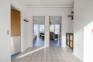 Un couloir avec un lit, une chaise et une table au fond.