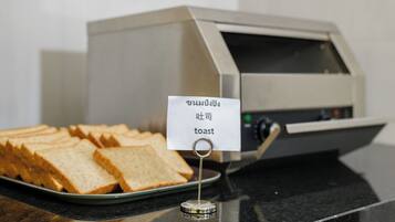 A toaster with a sign indicating it is for toast, and a plate of sliced bread.