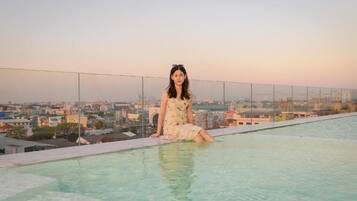 Una piscina al aire libre, sillones reclinables de piscina