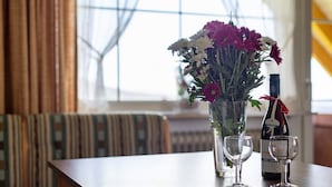 Ein Tisch mit einer Blumenvase, einer Weinflasche und zwei Weingläsern.
