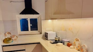 A modern kitchen with a microwave, toaster, and a window above the counter.