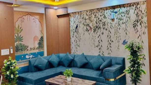 A modern living room with a sectional sofa, a wooden coffee table, and a decorative wall mural.