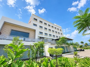 A modern building with multiple floors, large windows, and a balcony.