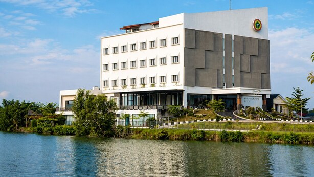 A modern building with a flat roof, multiple windows, and a sign indicating it is a hotel.