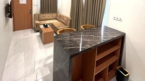 A modern living room with a sofa, a coffee table, and a marble island.