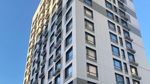 Un edificio alto y moderno con varios pisos, ventanas amplias y balcones.