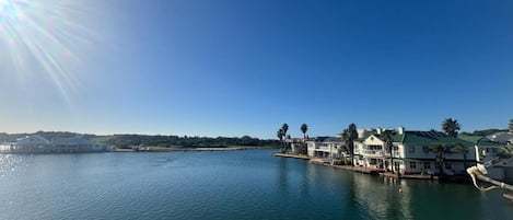 Ein Anwesen am Wasser mit mehreren Gebäuden, einer Anlegestelle und einem klaren Himmel.