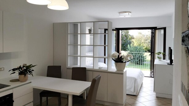 Une cuisine moderne avec un coin repas, une bibliothèque intégrée et un balcon offrant une vue agréable.