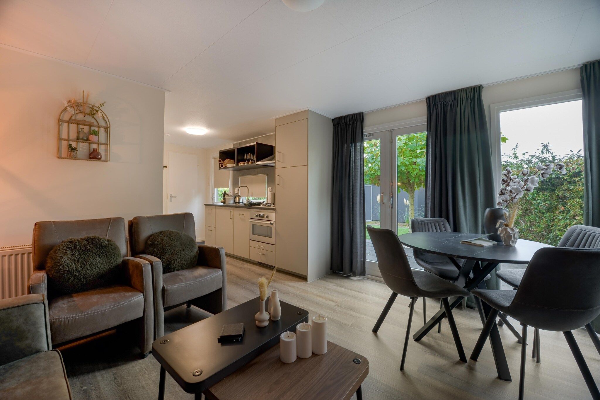 Uma sala de estar moderna com sofá, mesa de centro e área de jantar com cadeiras.