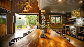 A spacious kitchen with a long wooden counter, modern appliances, and a view of the outdoors.