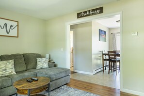 A living room with a sofa, a coffee table, and a sign that reads 'Archburg.' - The Fieldstone Getaway (Ellsworth)