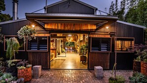 A modern house with a wooden exterior, a brick pathway, and potted plants.