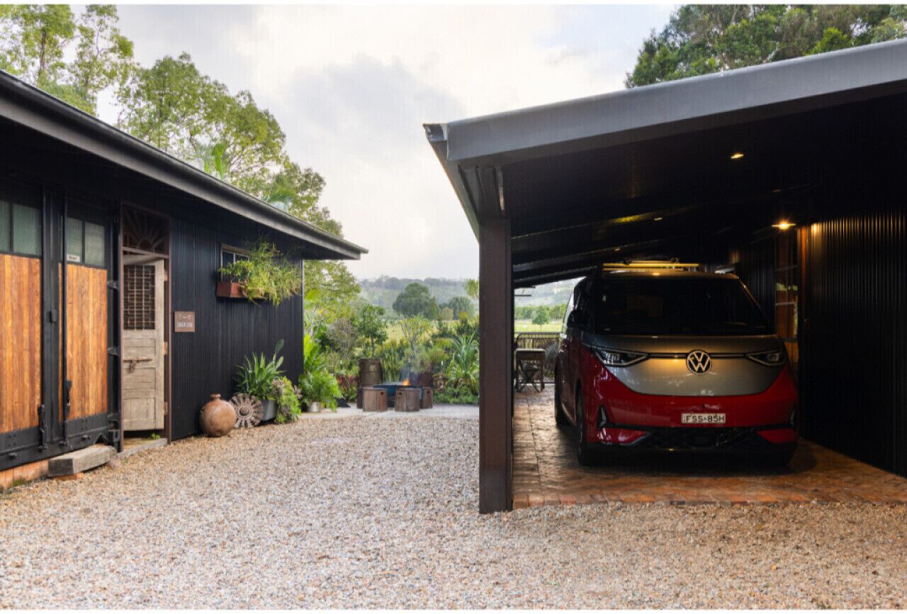 A modern building with a covered garage and a red car parked inside.