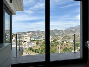 A large window with a view of a town and hills. - Casa Montemar (Almuñécar)