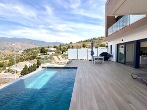 Ein moderner Poolbereich im Freien mit Blick auf die Landschaft.