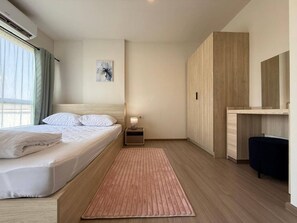 Ein Hotelzimmer mit Bett, Nachttisch, Lampe und Spiegel.