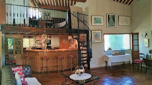 A spacious living area with a high ceiling, a bar, and a staircase. - L' ARC EN CIEL (Pujaut)