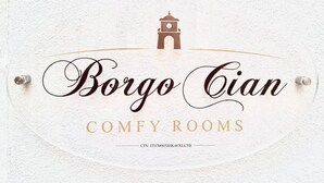 A sign with 'Borgo Cian COMFY ROOMS' and a CIN number.