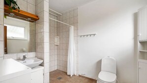 A bathroom with a sink, toilet, shower, and a mirror. - Sct. Knudsborg · Panorama apt 12E · Lillebælt (Middelfart)