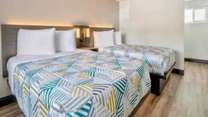 Habitación de hotel con dos camas, una mesita de noche y lámparas de pared.