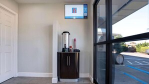 A coffee station with a coffee machine, a cabinet, and a digital clock on the wall. - 1 Queen Bed | Micfridge (Arcata)