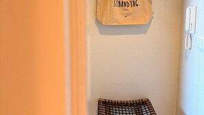 A room with a wooden bench, a hanging bag with 'STRANDTAG' text, and a black shelf. - Exclusive apartment with sea view in Haus Seeblick! - Lake view (Borkum)