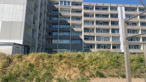A multi-story building with a modern architectural style, featuring balconies and large windows. - Exclusive apartment with sea view in Haus Seeblick! - Lake view (Borkum)