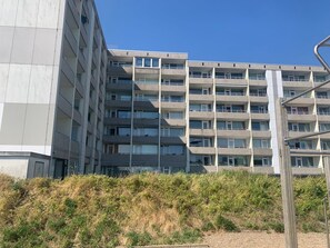 Ein mehrgeschossiges Gebäude im modernen Architekturstil, mit Balkonen und großen Fenstern.
