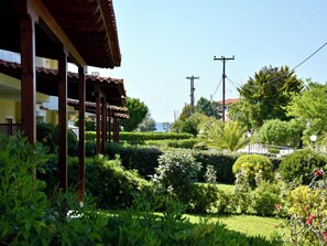 A garden with a variety of plants and a building with a tiled roof. - Relaxed family villa with garden, just steps from the beach in Fourka (Paliouri)