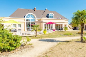 A house with a large patio, outdoor seating, and a well-maintained lawn. - Grand Loire Valley Family Maisonette (Azay-le-Rideau)