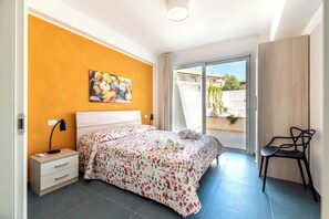 A bedroom with a bed, a nightstand, a desk, and a chair. - A Casa di Chica by Geco Vacation Rentals (Marina Di Ragusa)