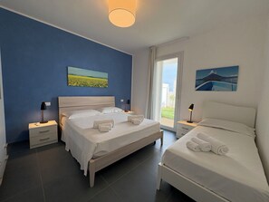 A hotel room with a large bed, a smaller bed, a nightstand, a bedside table, and a window with a view. - A Casa di Chica by Geco Vacation Rentals (Marina Di Ragusa)