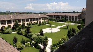Pátio com um edifício com várias arcadas e um espaço aberto central.