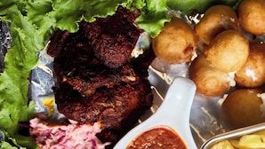 Diversos pratos com peixe frito, carne, salada de repolho e batatas fritas.